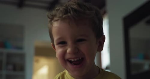 Close Up Portrait of Little Cute Boy Blowing Bubbles Towards the Camera and Laughing. Happy To