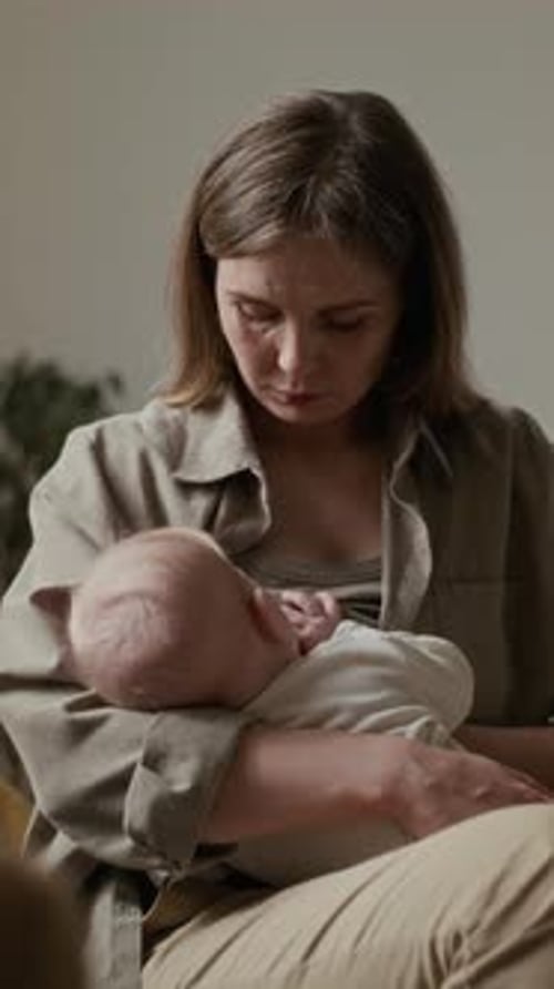Joven madre caucásica que sostiene a su bebé disfrutando del proceso de lactancia