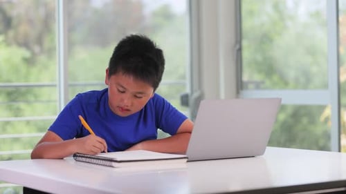 12-jähriger Junge arbeitet an seinen Schulhausaufgaben