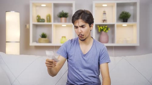 Young Man Reviews Receipt and Smiles