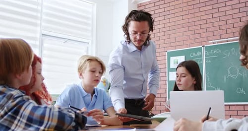Teacher Guides Students During Classroom Lesson