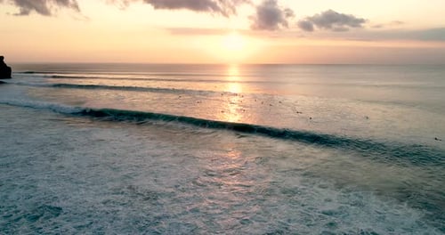 Aerial Shot Moving Fly Over Blue Ocean And Tropical Beach Cloudy Sunset Dawn with many Surfer views