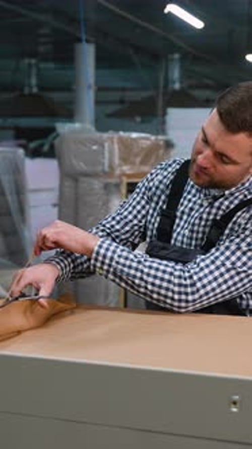 Worker Prepares Fabric for Sofa Base Upholstery