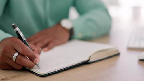 Person Writing and Typing in Bright Workplace