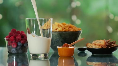 Milk Being Poured Beside Berries and Cornflakes