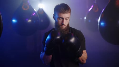 Portrait of the Beard Caucasian Boxer Standing on the Boxing Gym Background Wearing Special Boxing