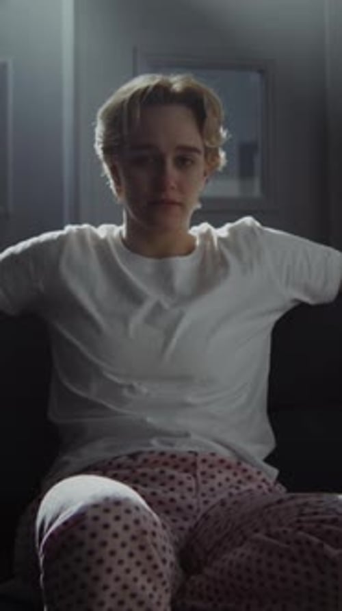 Thoughtful Young Adult Sitting on Couch Indoors