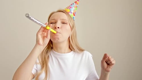 Woman Celebrates Birthday with Party Blower and Hat