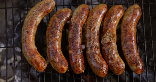 Delicious juicy sausages, cooked on the grill with a fire.