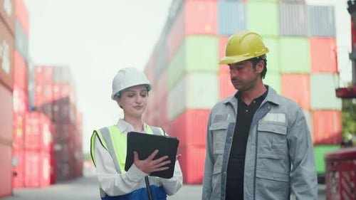 Professional female and male logistics managers using a digital tablet