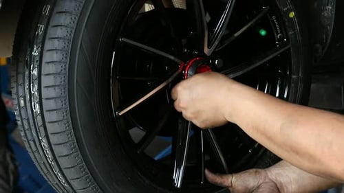 Car mechanic replace tire on wheel in auto repair service.