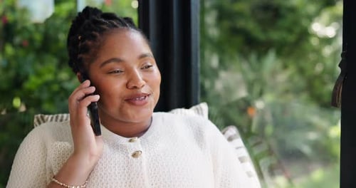 Woman with Braids Happily Talking on Phone Indoors