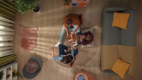 Top View of Living Room Mother Father and Son Sitting on the Floor Eating Big Pizza and Talking