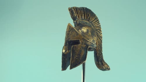 A rotating close up shot of a spartan warrior ancient greek metal bronze helmet, with shapes and for