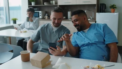 Hospital Coworkers Using Phone and Chatting in Break Room