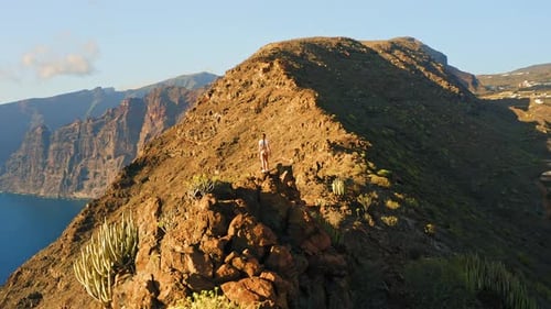 Hiker Girl Relaxing on Rocky Mountain Top Enjoying Sunset Nature in Travel Wilderness Trail