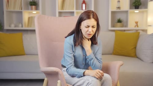 Woman Suffering with Sore Throat in Living Room