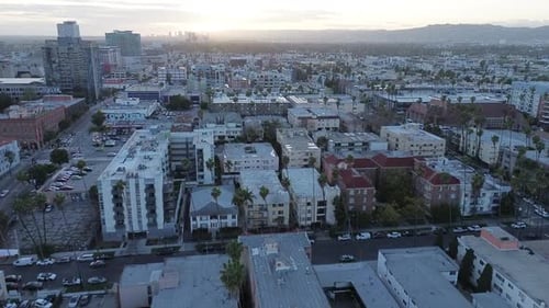 Push in drone shot of urban city neighborhood at sunset.