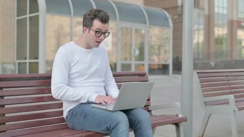 Young Adult on Laptop Reacts to Good News