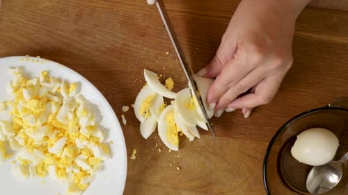 11Boiled egg cut into pieces with a knife. Cooking dishes with eggs.