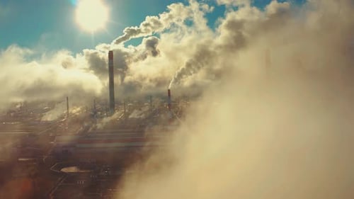 Power plant smokes. Aerial view of the power plant with smoking pipes and clouds passing by