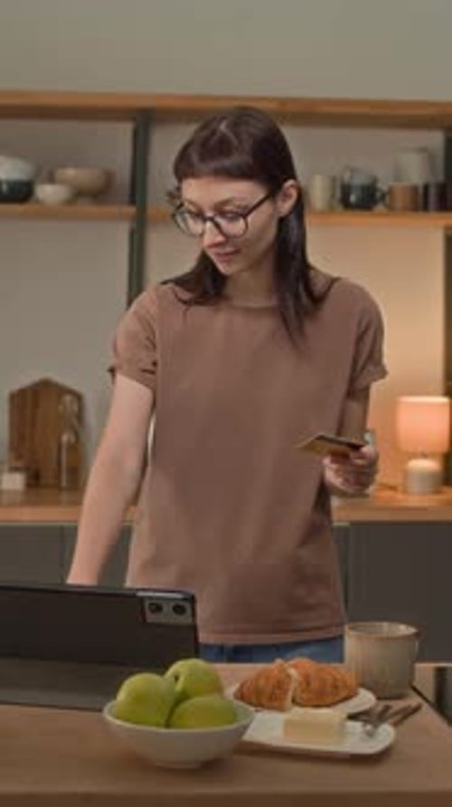 Young Woman Smiling, Using Tablet in Kitchen