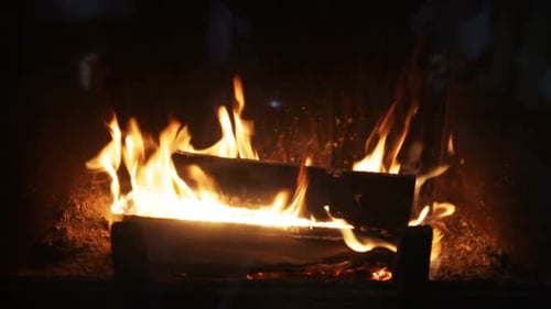 Burning Fireplace Logs Provide Warmth in Dark Room
