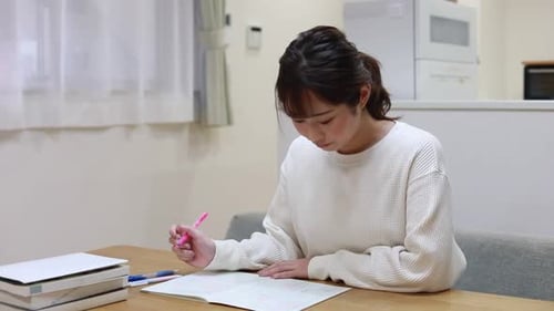 Young Woman Studying at a Table Indoors