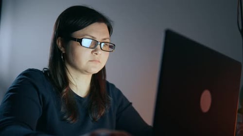 Woman Works on Laptop at Night
