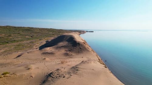 Desert Dune with Blue Sea at Sunrise