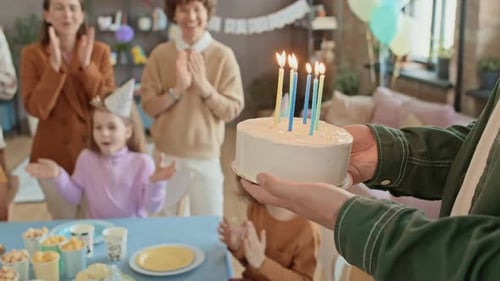Children and Adults Celebrate Birthday with Cake and Candles