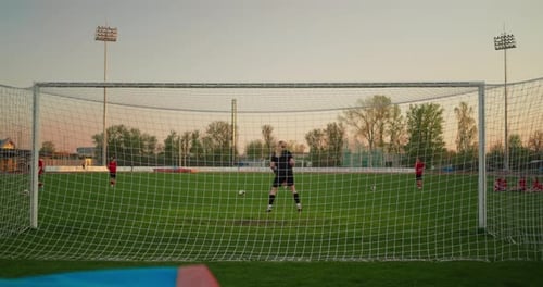 Goalkeeper Dives Across the Penalty Area During Soccer Practice Viewed Through the Goal Net on a