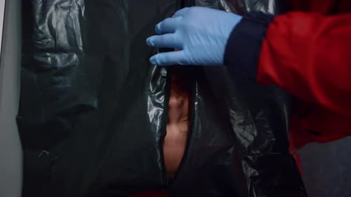 Medical Examiner Zipping Up Body Bag on Table