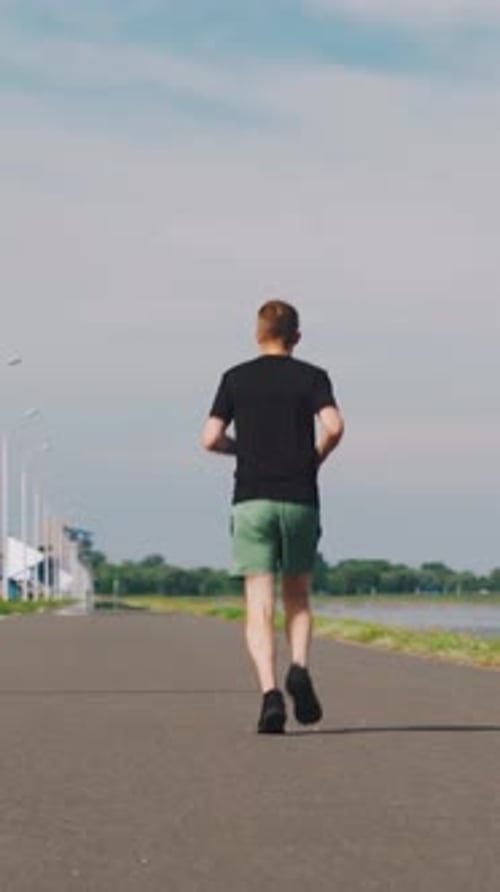 Young Adult Running on Path by Water