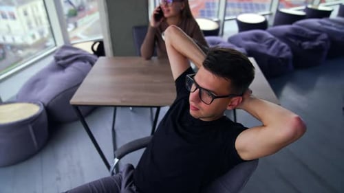 Détendez-vous après le travail au bureau. L'homme était allongé sur sa chaise, les jambes posées sur la table.