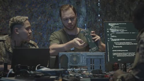 Military Workers Inspecting Circuit Boards in Dark Office