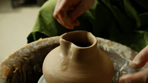 A pot in the shape of a heart is ready at the pottery workshop on the pottery wheel