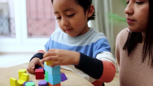 Child Playing with Colorful Blocks with Adult