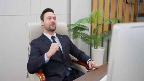Satisfied businessman finished work on computer sitting at desk at workplace in business office.