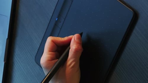Illustrator drawing on laptop with graphics tablet and stylus. Vertical video