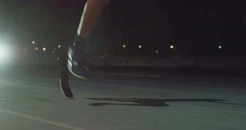 Cinematic close up of disable man with legs prosthesis running with effort with racing auto behind