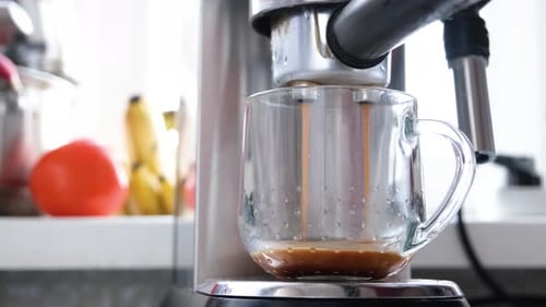 Pouring coffee stream from machine to cup