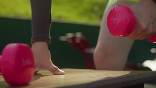 Woman Working Out Doing Dumbbell Rows Outside