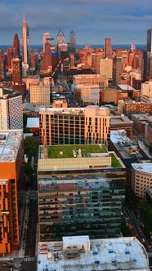 Facades of Philadelphia buildings lit with setting sun.