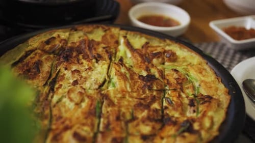 Buchimgae - Plate Of Korean Pancake Served On Table In A Korean Restaurant. - close up