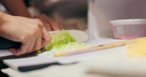 Hands Finely Mincing Scallions with Knife in Kitchen