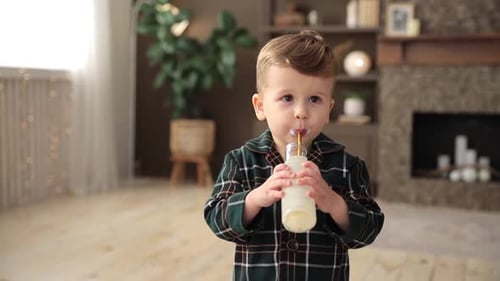 Adorable Toddler Boy Drinks Milk or Yogurt Through an Ecological Straw Concept of Conscious Care for