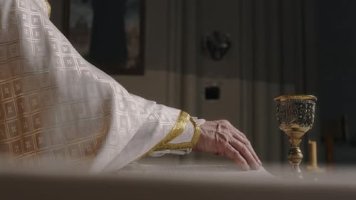 Pastor hebt Kelch während der Kommunionzeremonie in der Kirche