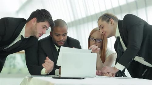 Four Colleagues Collaborating on Project in Modern Office