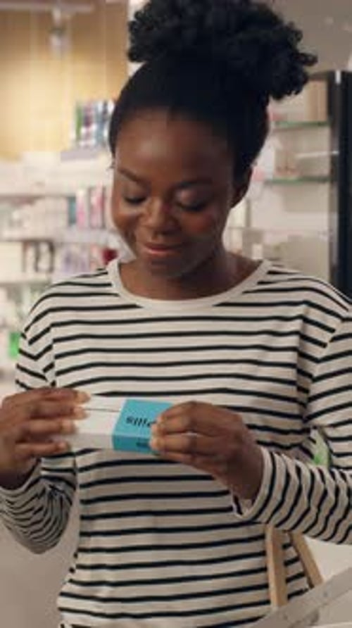 African American Woman Buying Medicine Drugs Vitamins Health Care Supplements in Pharmacy Healthy